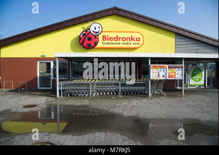 Parked shopping carts equipped with coin-operated locking mechanisms in Biedronka supermarket in the beginning of law restriction for Sunday shopping  Stock Photo