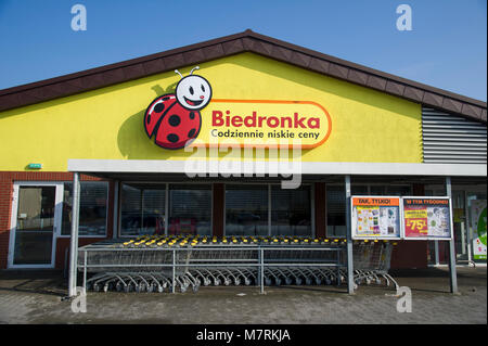 Parked shopping carts equipped with coin-operated locking mechanisms in Biedronka supermarket in the beginning of law restriction for Sunday shopping  Stock Photo