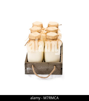 a  traditional glass milk bottles in a wooden tray isolated on a white Stock Photo