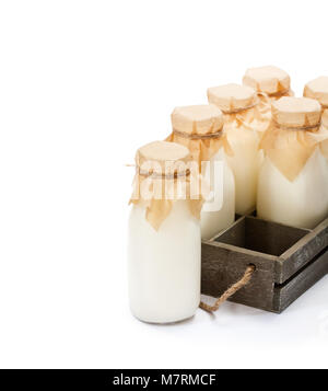 a  traditional glass milk bottles in a wooden tray isolated on a white Stock Photo