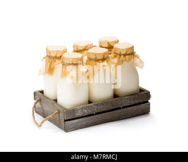 a  traditional glass milk bottles in a wooden tray isolated on a white Stock Photo