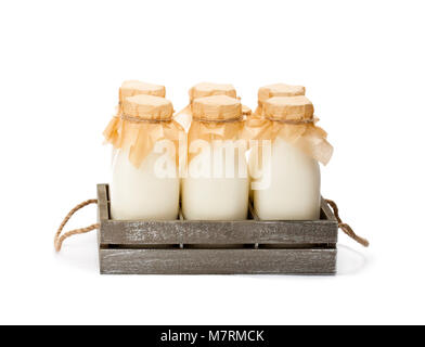 Traditional  glass milk bottles in a wooden tray isolated on a white Stock Photo