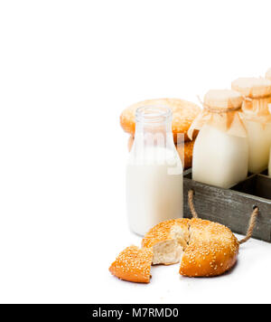 Traditional  glass milk bottles with bagels isolated on a white Stock Photo