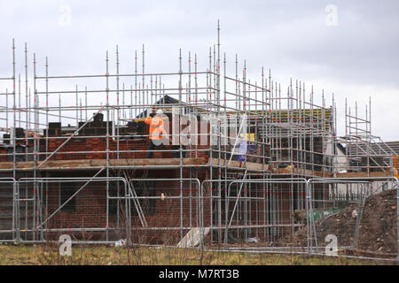 Bricklayer working on the construction of a new house in a residential development Stock Photo