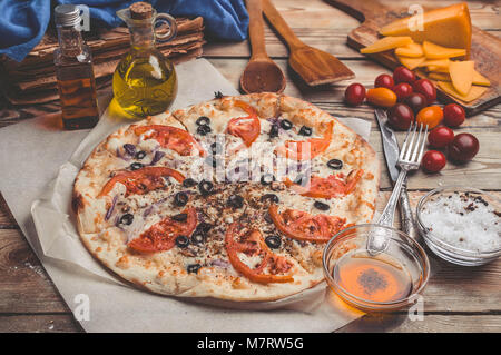 Pizza Margarita on thin crust. Food composition on a wooden background. Mediterranean traditional cuisine. Easy vintage toning Stock Photo