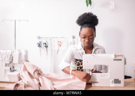 african seamstress sews clothes. Workplace of tailor - sewing machine ...