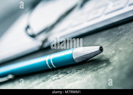 Macro Of A Blue Pencil, Glasses And White Keyboard On Slate Stock Photo