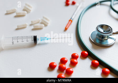 Chemical medicine pills, stethoscope and syringe on white background Stock Photo