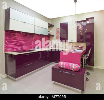 Kitchen with shinny burgundy doors and pink island and white ceramic floor Stock Photo