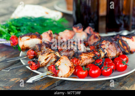 Flavored pork shish kebab with vegetables on skewers close-up on the table Stock Photo