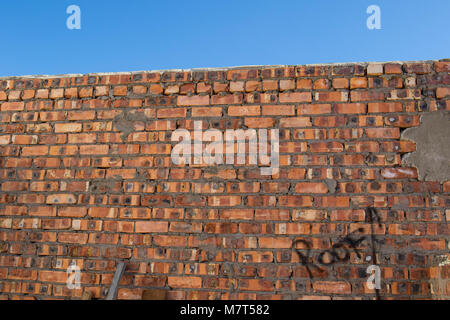 Raw brick wall with the word roof and an arrow pointing upwards painted on it image in landscape format with copy space Stock Photo