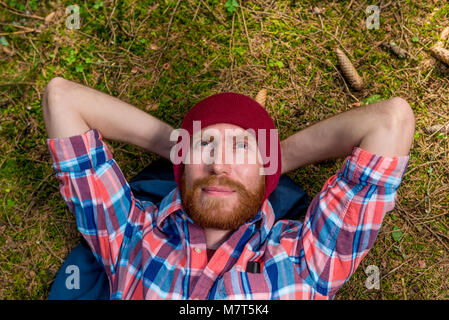 dreamy hipster on the ground in the woods resting and looking at the sky Stock Photo