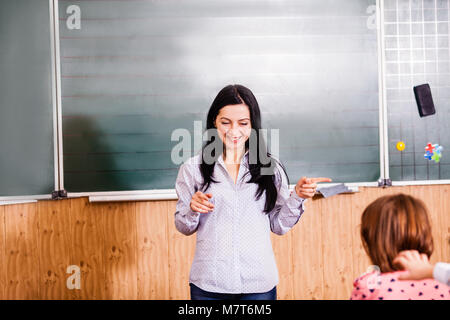 Smiling teacher explains Stock Photo