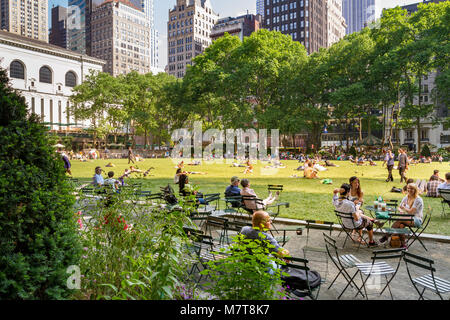 People enjoying a Summer's day in  Bryant Park a City park in Mid-town Manhattan,  New York City , NY ,USA Stock Photo