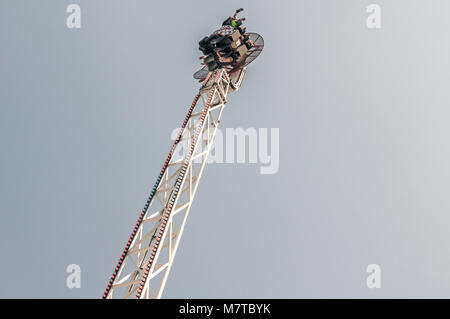 people hanging upside down in a fairground attraction Stock Photo