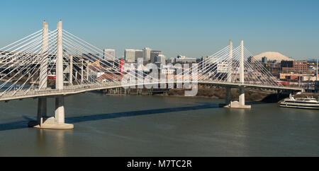 It's a clear day in Portland Oregon at Tilikum Crossing as people traverse the river with Mount St. Helens in the background Stock Photo