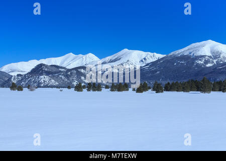 mountains bordering the scapegoat wilderness rising above kleinschmidt flat in winter near ovando, montana Stock Photo