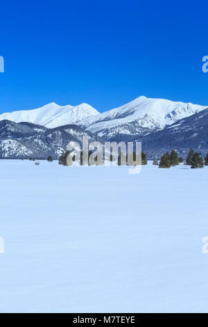 mountains bordering the scapegoat wilderness rising above kleinschmidt flat in winter near ovando, montana Stock Photo
