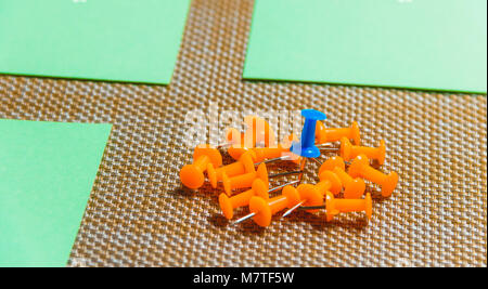 Stationary, Orange, Blue Pushpins Heap on Brown Background, Concept for Difference, Individuality. Stock Photo
