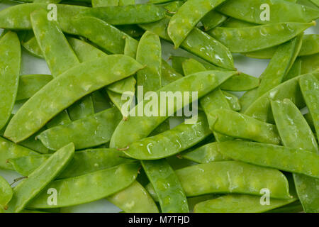 Close up of freshly green rinsed raw snap peas on white background Stock Photo