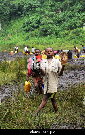 Congolese villagers fill their water supply from this Muddy pond. The only good water source they have. Stock Photo