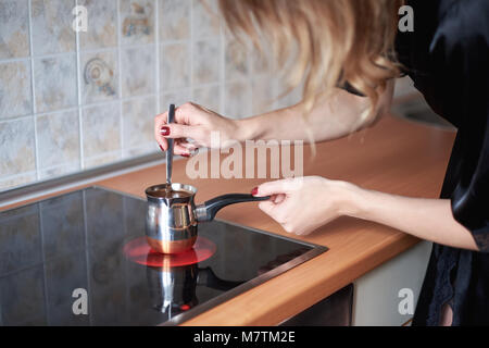 Cooking coffee in traditional copper turkey on a stove - kitchen interior Stock Photo