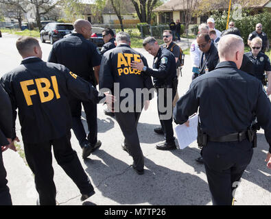 Agents from the FBI and Bureau of Alcohol, Tobacco and Firearms (ATF) walk in a residential neighborhood in east Austin where a package bomb exploded Monday, injuring an elderly Austin resident. The incident followed bombings two weeks ago and earlier Monday that killed two people and injured another. Stock Photo