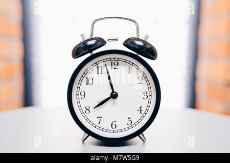 Retro alarm clock on table on white background Stock Photo