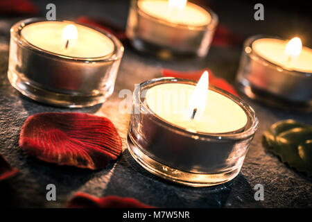 4 Valentine Candlelights On Slate With Rose Petals And Leafs Stock Photo