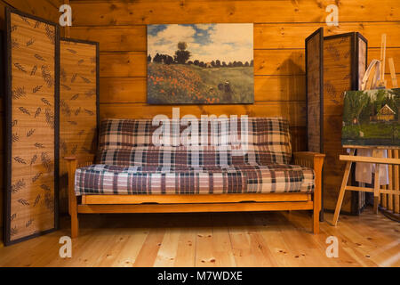 Sofa on the mezzanine inside a Canadiana cottage style residential stacked white pine log home Stock Photo