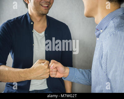 Fist Bump making by two men smiling Stock Photo