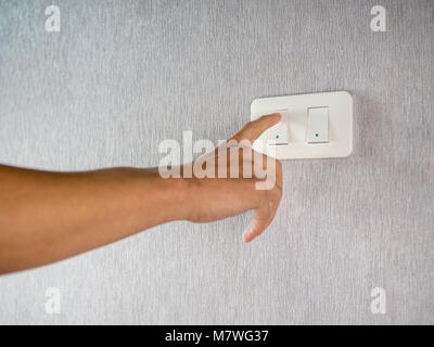 Switching on off light switcher on wall Stock Photo