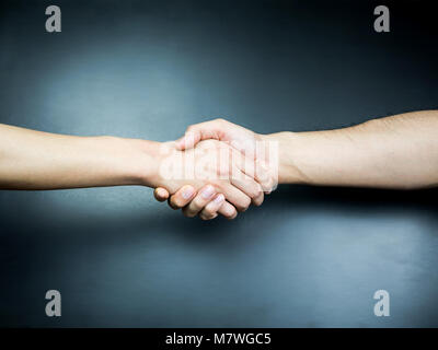 Two handed handshake on black background Stock Photo