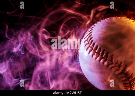 Close up of a white baseball ball in multi-colored red smoke from a vape on  a black isolated background Stock Photo - Alamy