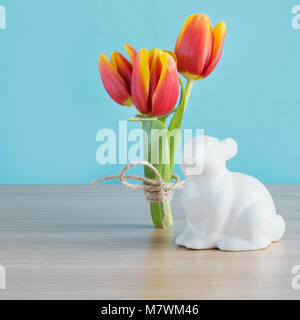 White rabbit and tulip on wooden board. Easter composition. Close up. Stock Photo