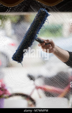 a soapy window with a squeegee cleaning the glass Stock Photo