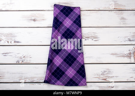 Purple checkered skirt. Wooden desks surface background. Stock Photo