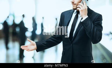 on the left side of the photo - close up of serious businessman talking with a partner on the background of the office. On the right side of the photo Stock Photo