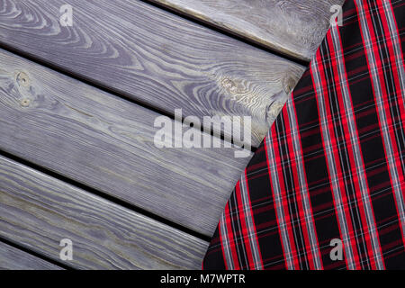 Extreme close up checkered clothes material. Grey wooden surface background. Stock Photo