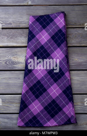 Purple checkered skirt. Grey wooden surface background. Stock Photo