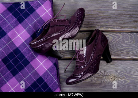 Close up purple shiny heel shoes. Violet checkered clothing. Stock Photo
