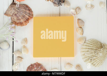 orange sheet of paper and seashells on a wooden background.Travel background Stock Photo