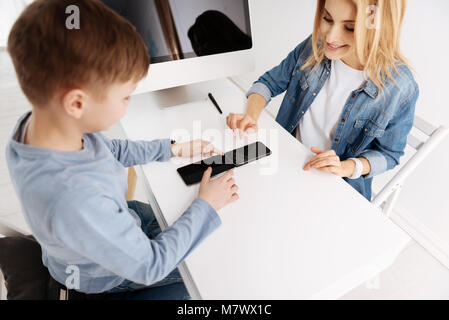 Positive cheerful mother and son using their gadgets Stock Photo