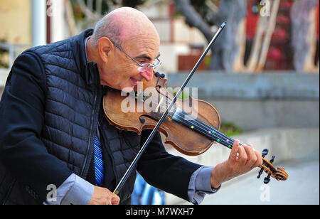 Seaport Village, San Diego, California: Smiling elderly gentleman plays the violin for passers by. Stock Photo