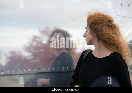 woman taking a passing look at reflection in side of American style diner like a huge mirror Stock Photo