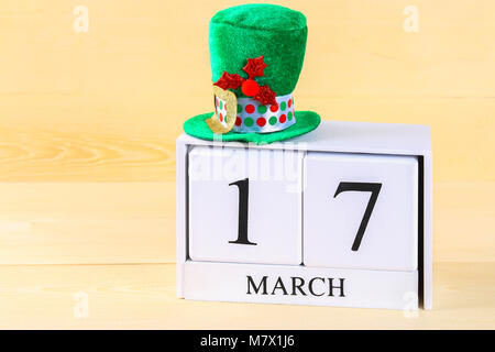 A green hat on a wooden table. St.Patrick 's Day. A wooden calendar showing March 17 Stock Photo