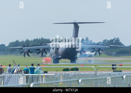 airbus a400m landing at air show with smoke coming from wheels and crowd watching Stock Photo