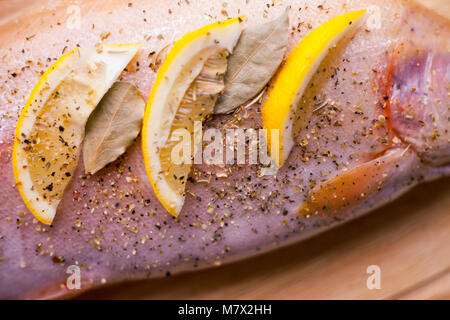 Raw fresh salmon, seasoned with lemon and spices, pickle. On wooden cutting Board Stock Photo