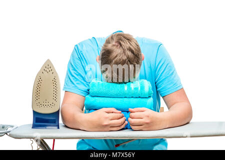 a very tired man fell asleep while ironing towels, a portrait is isolated Stock Photo