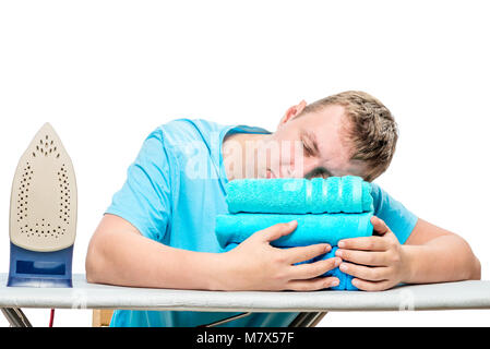 the man at the ironing time fell asleep on the ironing board, his head is on the towel Stock Photo